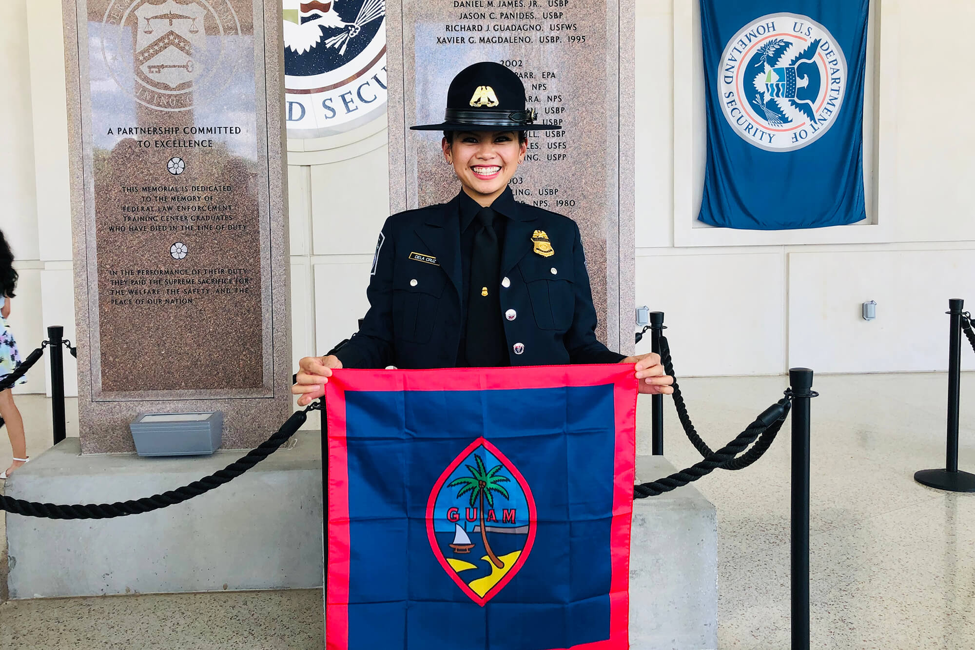 Kim Dela Cruz holds the Guam flag after her graduation