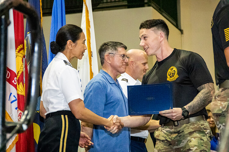 Michael Schommer, a ROTC cadet shakes hands at a Veterans Day ceremony on Nov. 12