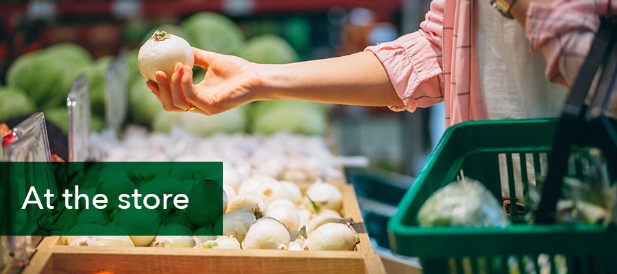 Photo of a lady choosing onions at a grocery store