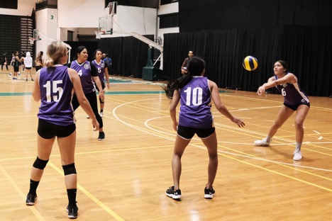 Laressa Halladay returns the ball from backcourt while teammates look on.