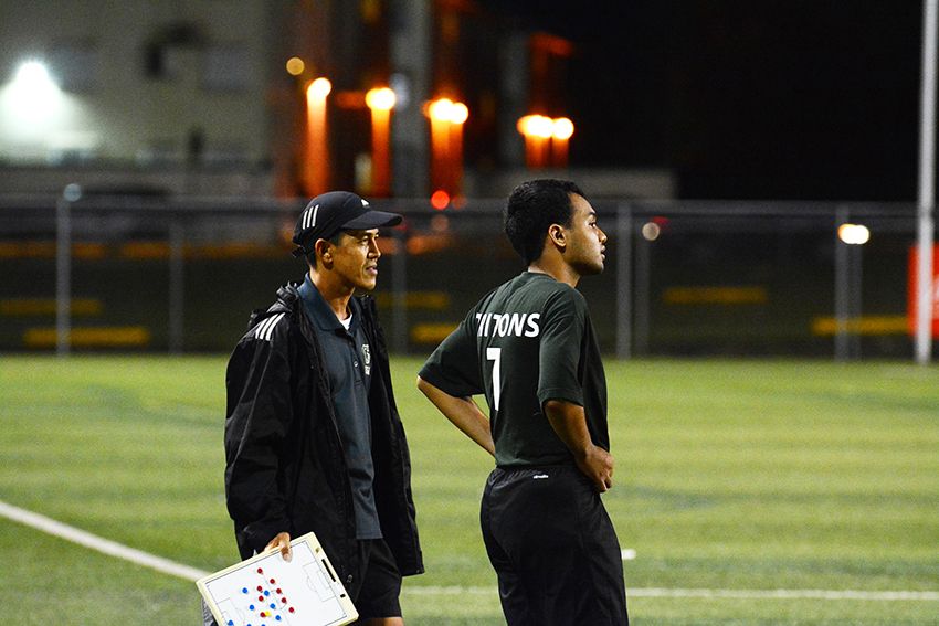 Photo of Coach Hidalgo at a soccer field with the men's soccer team