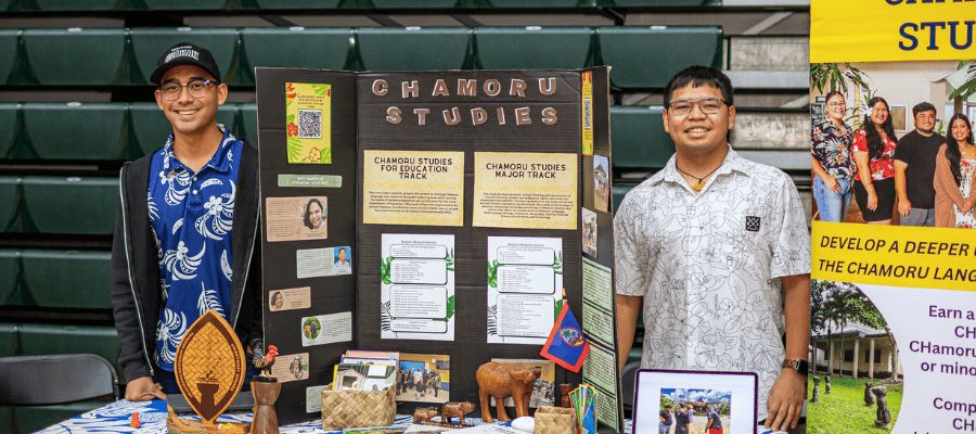 A photo of two male individuals presenting information on Chamoru Studies