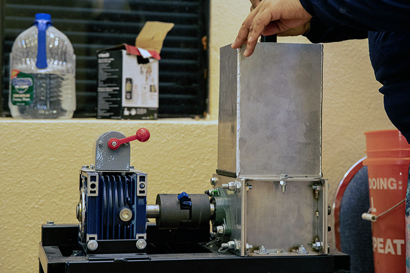 Photo of staff member pressing recycled plastic