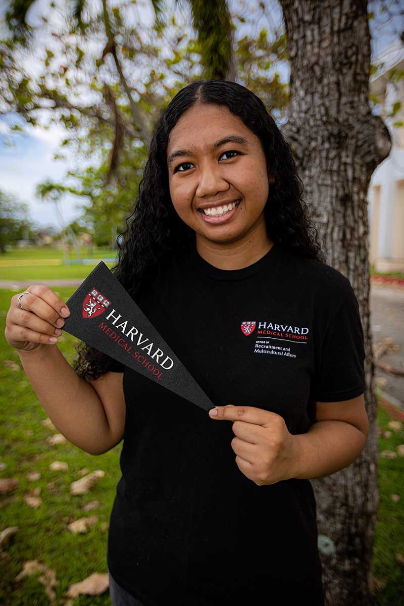 '20 Class Valedictorian Megan Gimmen holds a pennant from Harvard Medical School