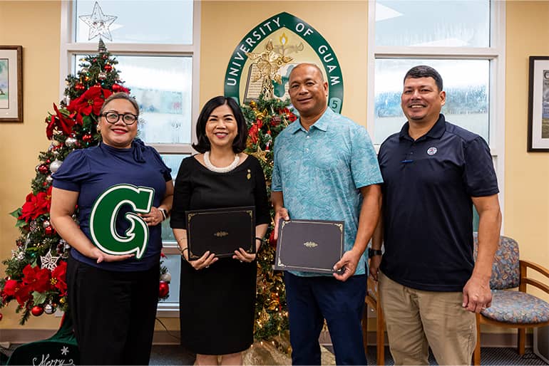 UOG admin pose for a photo at Memorandum of Understanding signing