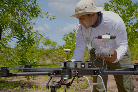 A man controls a drone and its propellers.