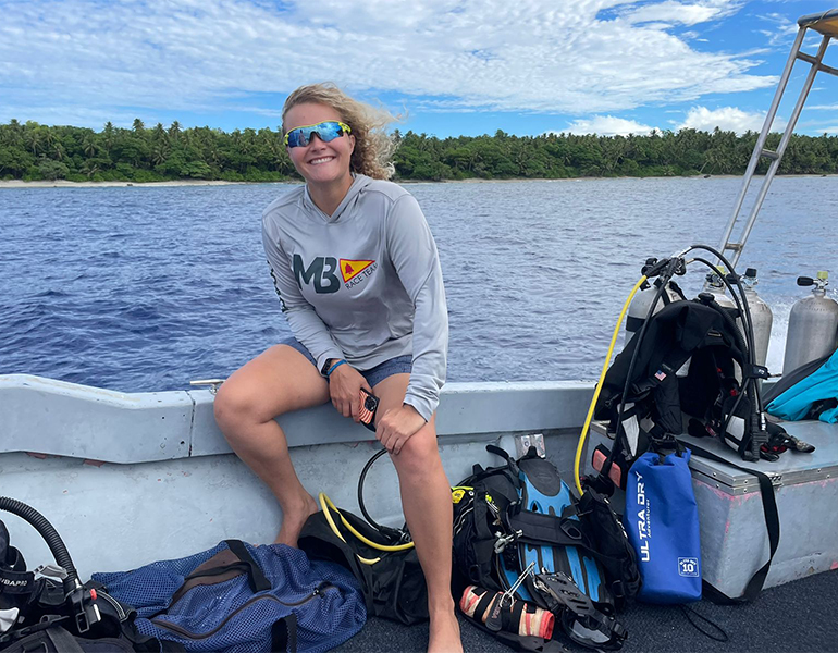 D’amy Steward sits at the edge of a boat.