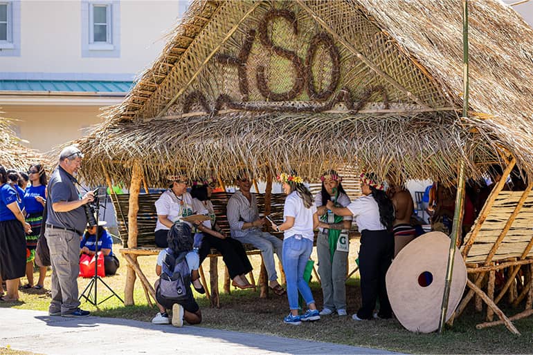 Participants from Yap Student Organization pose near hut after winning hut-building competition.