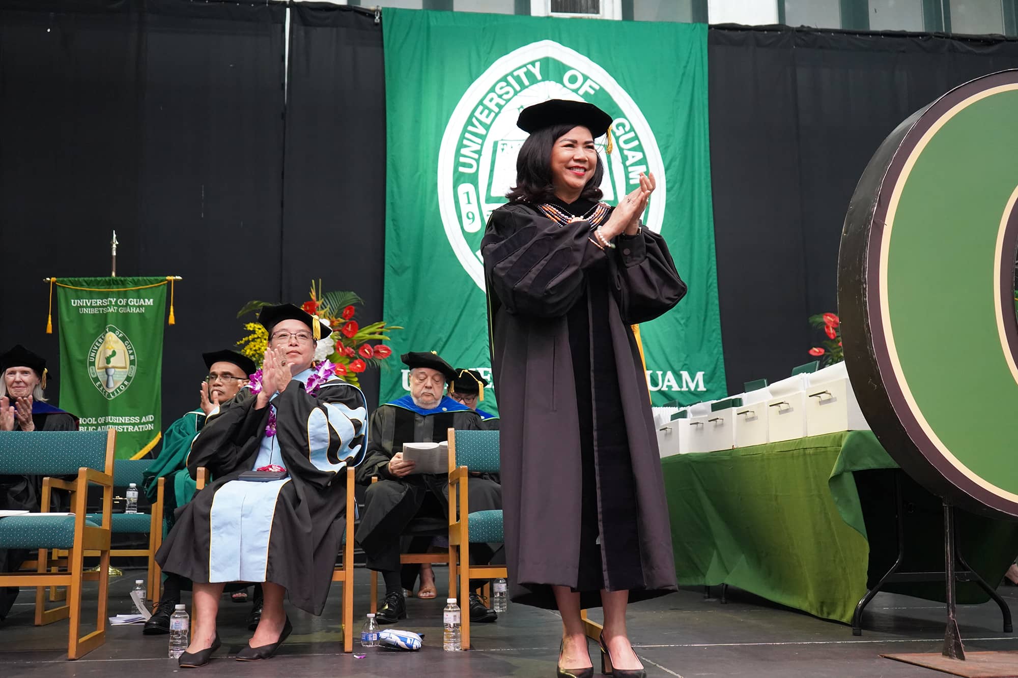 President Anita Enriquez applauds graduates