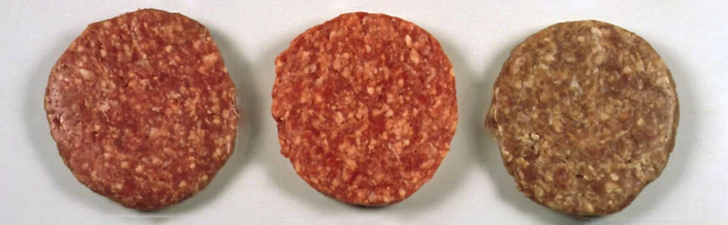 Three different colors of meat patties lined side by side