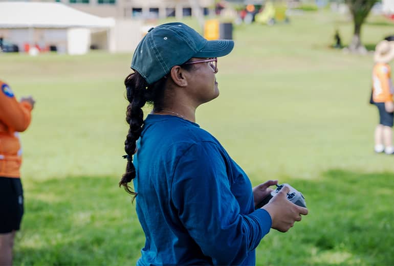 Ajalyn Omelau controls drone outdoors with remote control