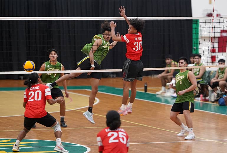 Action shot of UOG men’s volleyball players after getting the ball over to the other team