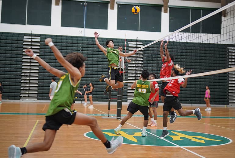 UOG men's volleyball team member goes for a spike