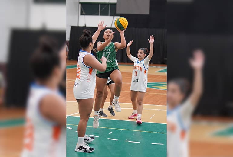 Amanda Uncangco shoots basketball as opponents block