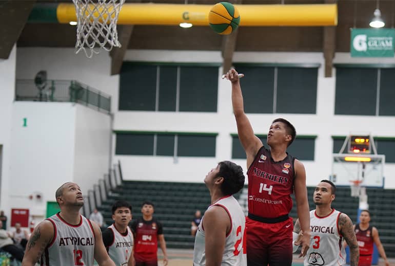 Team member in red jersey shoots basketball over teammates