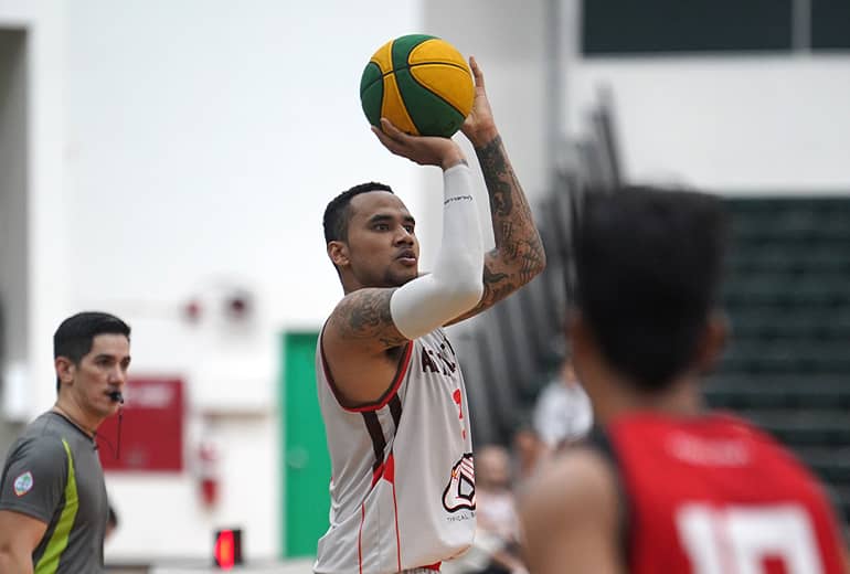 Basketball player in white jersey aims to shoot basketball in hoop