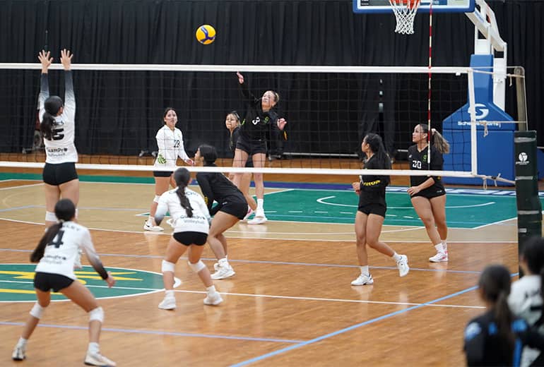 GuamPro1 volleyball player attempts to block spike from opposing team