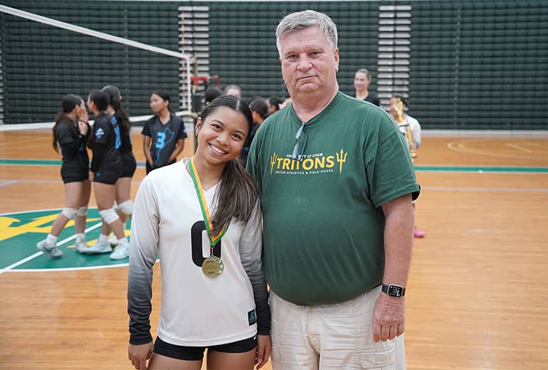 Volleyball team member poses with coach