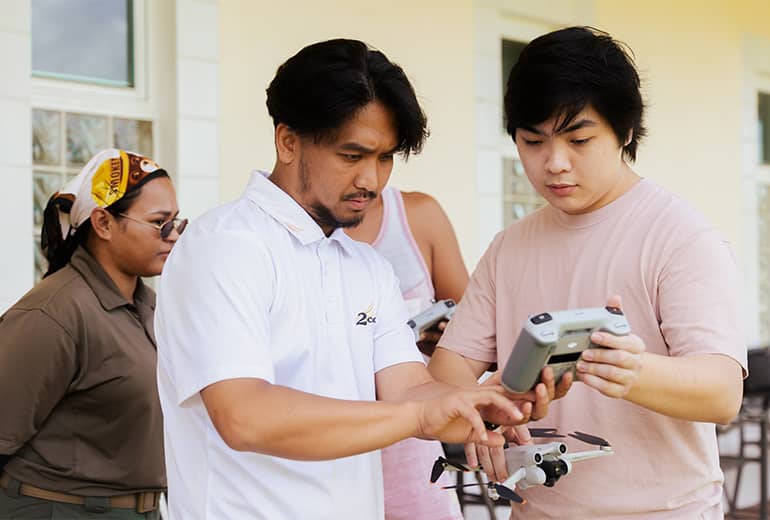 2cofly instructor teaches UOG Drone Corps member how to fly drone