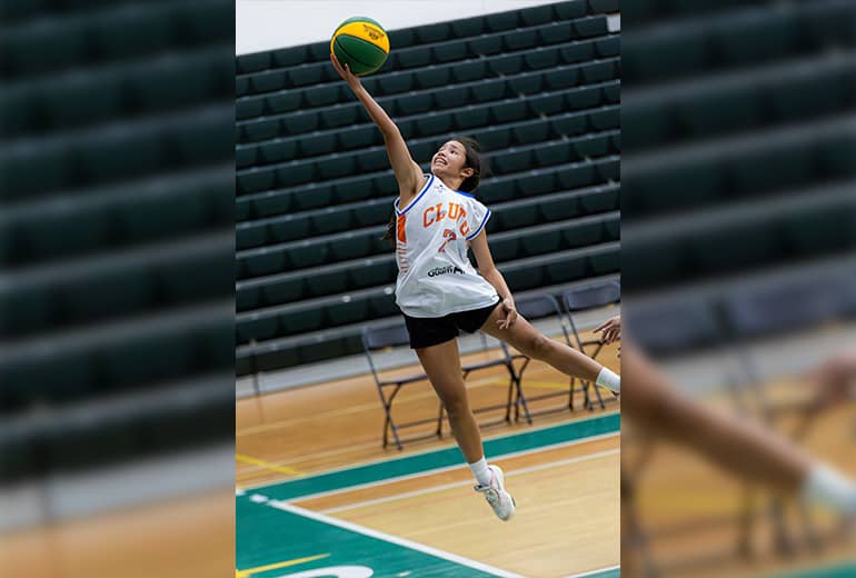 Athlete shoots basketball into hoop for Super League 